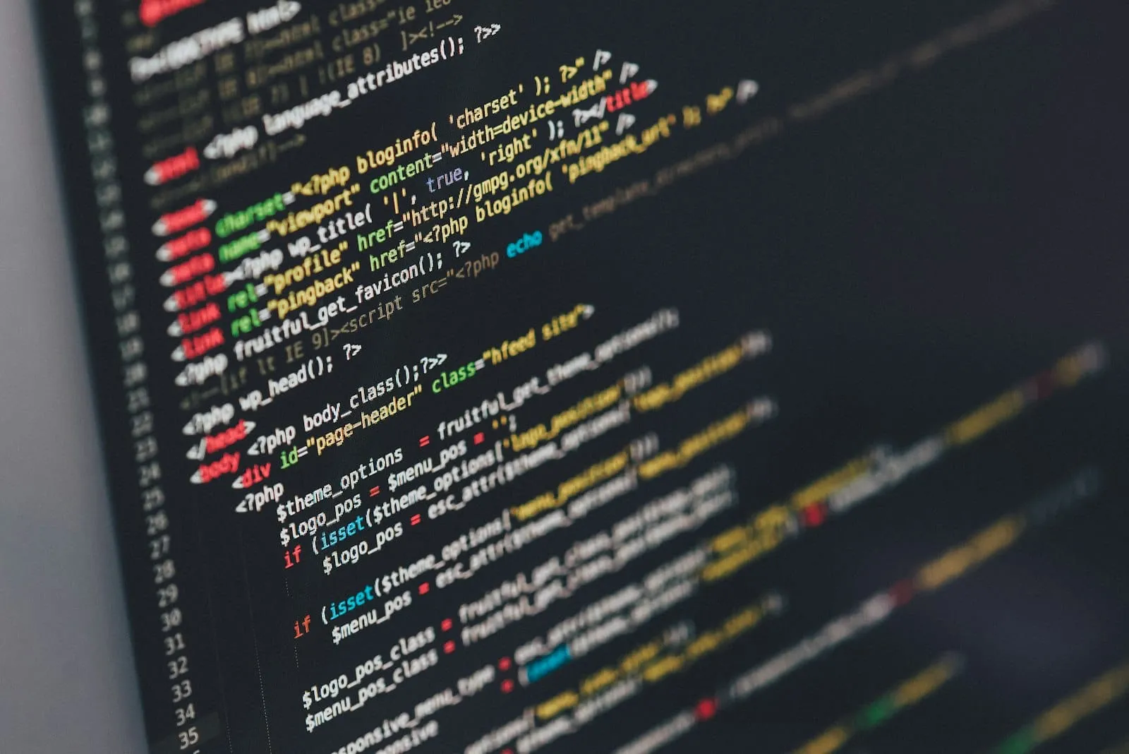 Developer reviewing front-end code and icon assets on multiple monitors