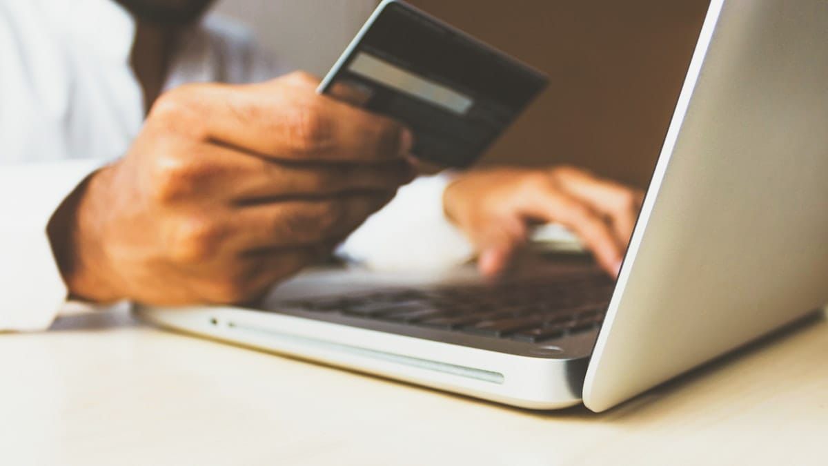 Person shopping online with credit card and laptop — e-commerce video can boost conversion rates