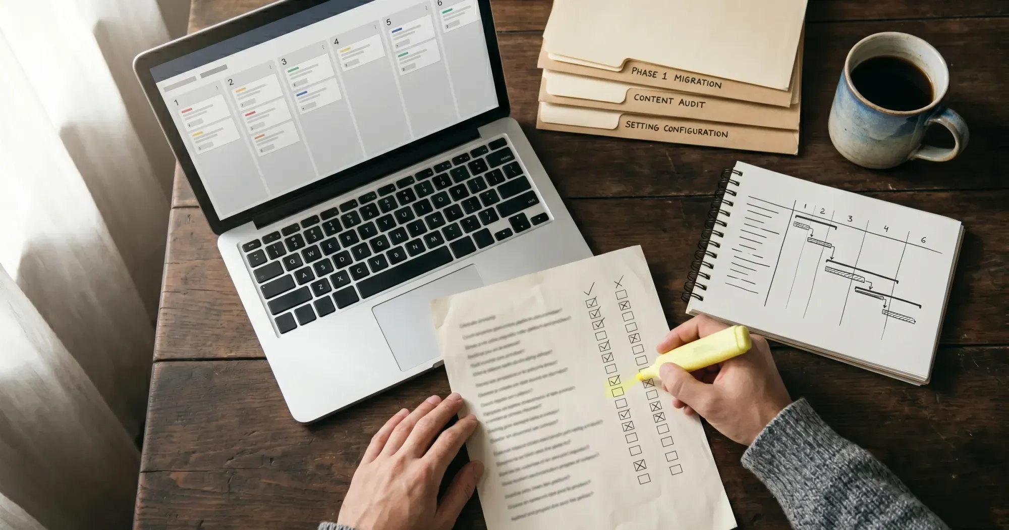 Overhead view of a course creator planning a video platform migration at a wooden desk with laptop, checklist, and project folders