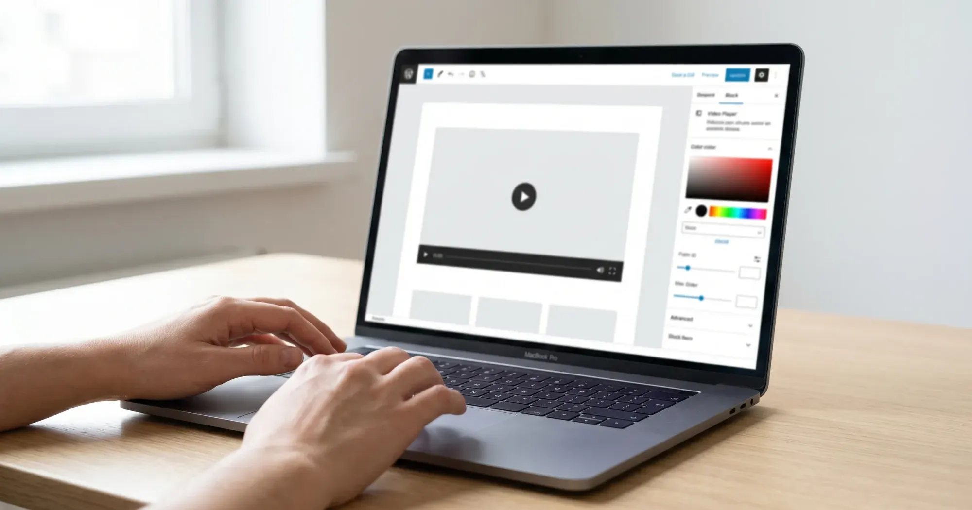 Hands on a laptop showing a website builder with a video block and settings panel open