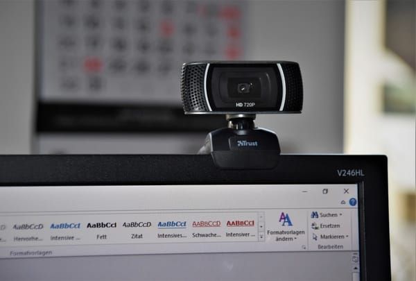 A streaming setup with webcam, microphone, and monitor showing a live broadcast workflow
